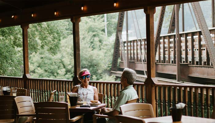 Outdoor dining at Juniper's Restaurant in Lanesboro, MN on the deck overlooking the Root River Trail Pedestrian Bridge